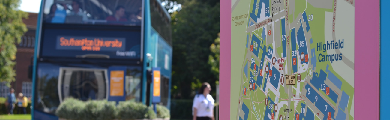An image of a UniLink bus out of focus, close to a campus map. 